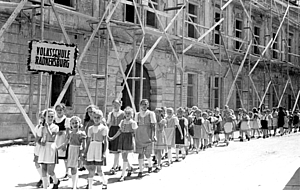 Volksschulkinder vor dem zerstörten Hauptschulgebäude, 1946. MiaZ