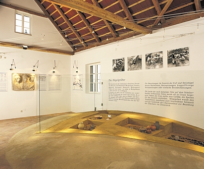 Blick in das Museum, im Vordergrund der rekonstruierte Grabhügel mit seinen fünf Bestattungen