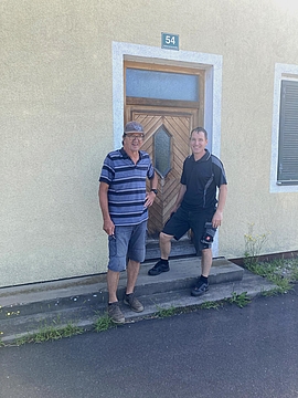Die Mitglieder der FF Altneudörfl, Franz Lustinger und Robert Hammler vor dem Eingang zum ehemaligen Kühlhaus, Juli 2022. Foto: MiaZ